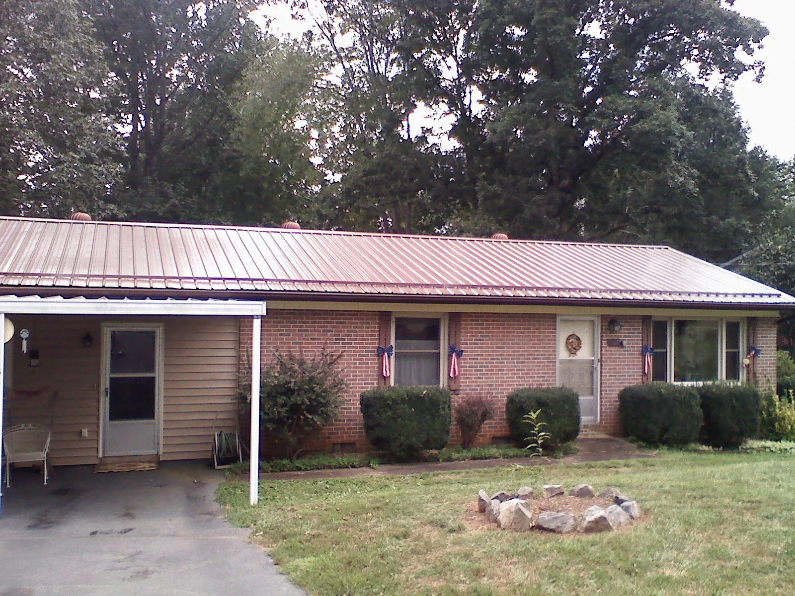 Bronze metal roof and carport on a brick ranch home — Roof Repair work by our crew in Basin